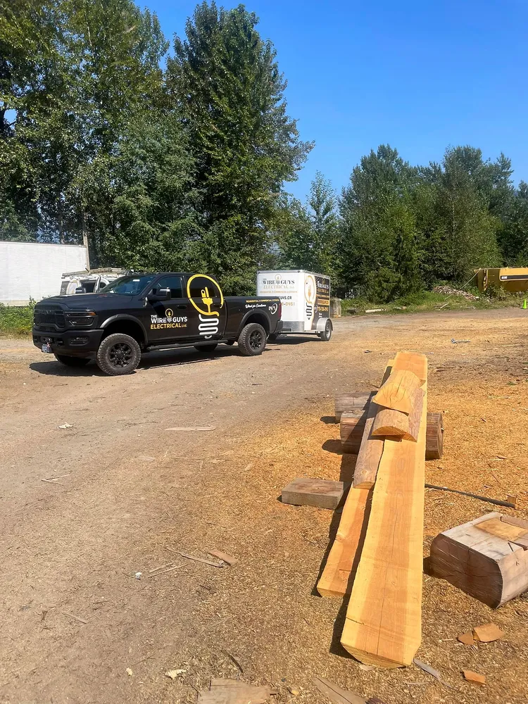 The Wire Guys pickup truck with its trailer on a gravel road at a build site