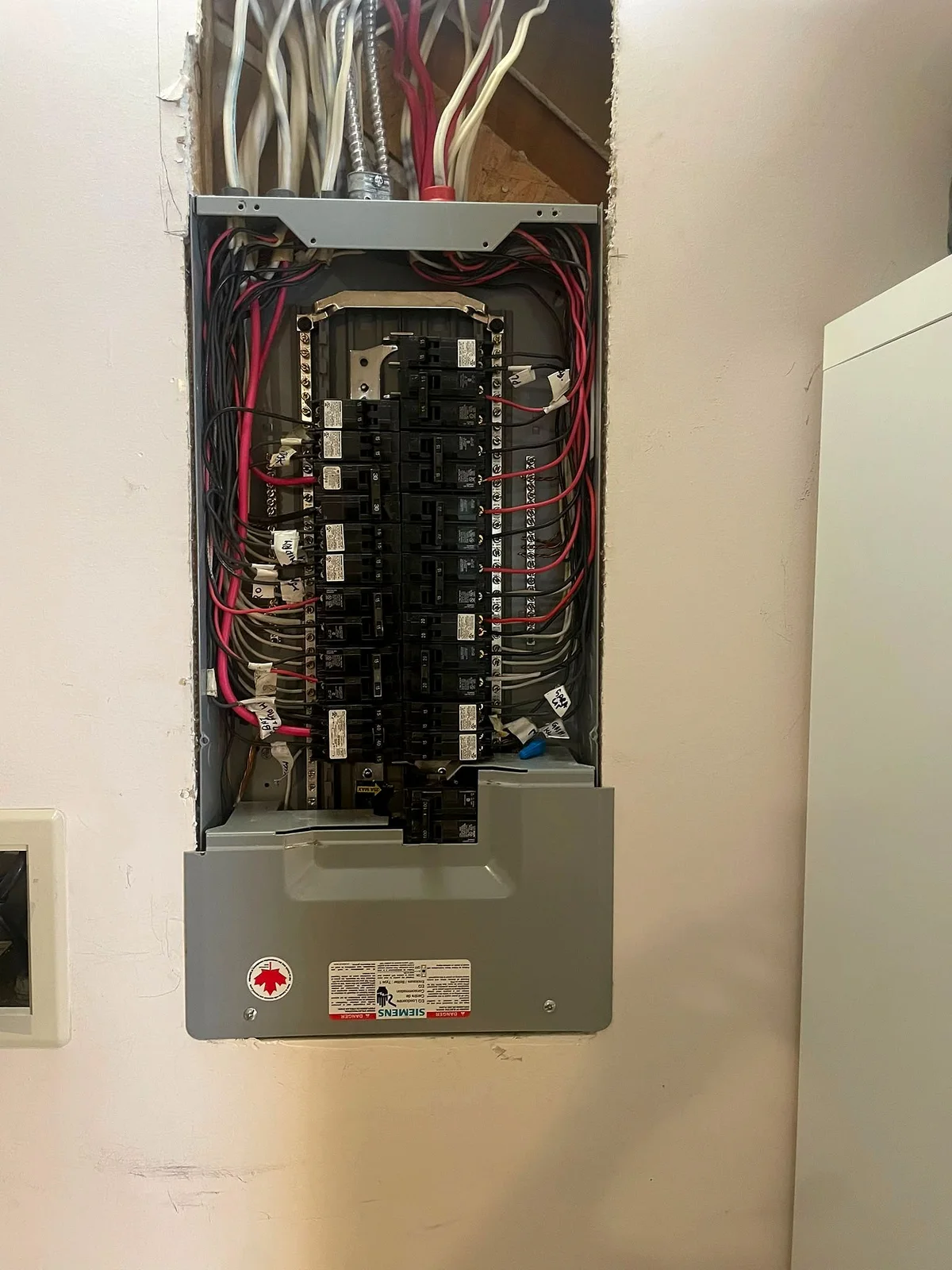 Electrical panel with the cover off, a full row of breakers installed and every circuit wire landed