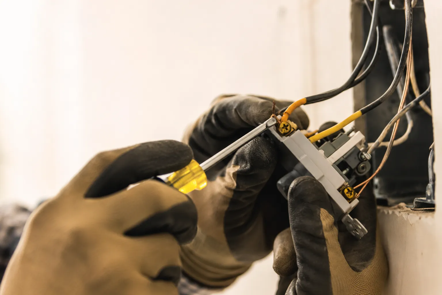 Gloved hands terminating a receptacle, the everyday work of an electrician British Columbia homeowners rely on